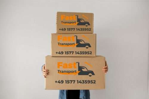 ein Mann hält drei Kisten, auf jeder Kiste befindet sich das Logo von Fast Transport.