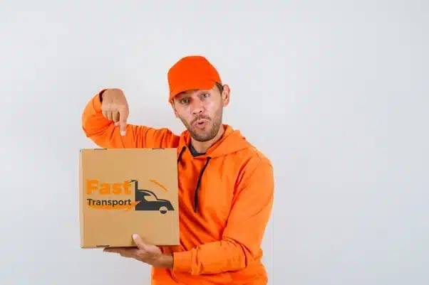 ein junger Mann zeigt auf eine Kiste